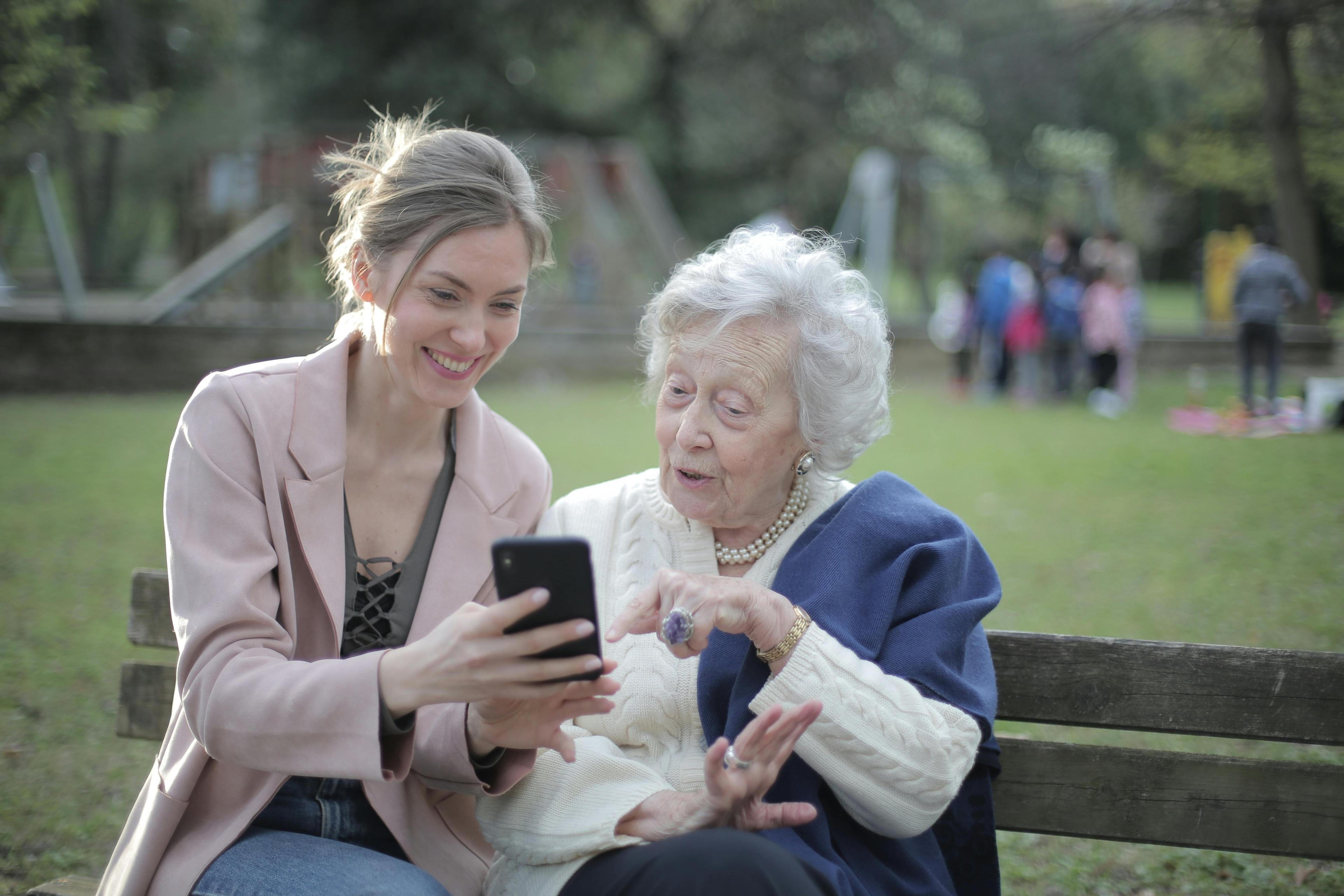 People smiling while looking at a phone